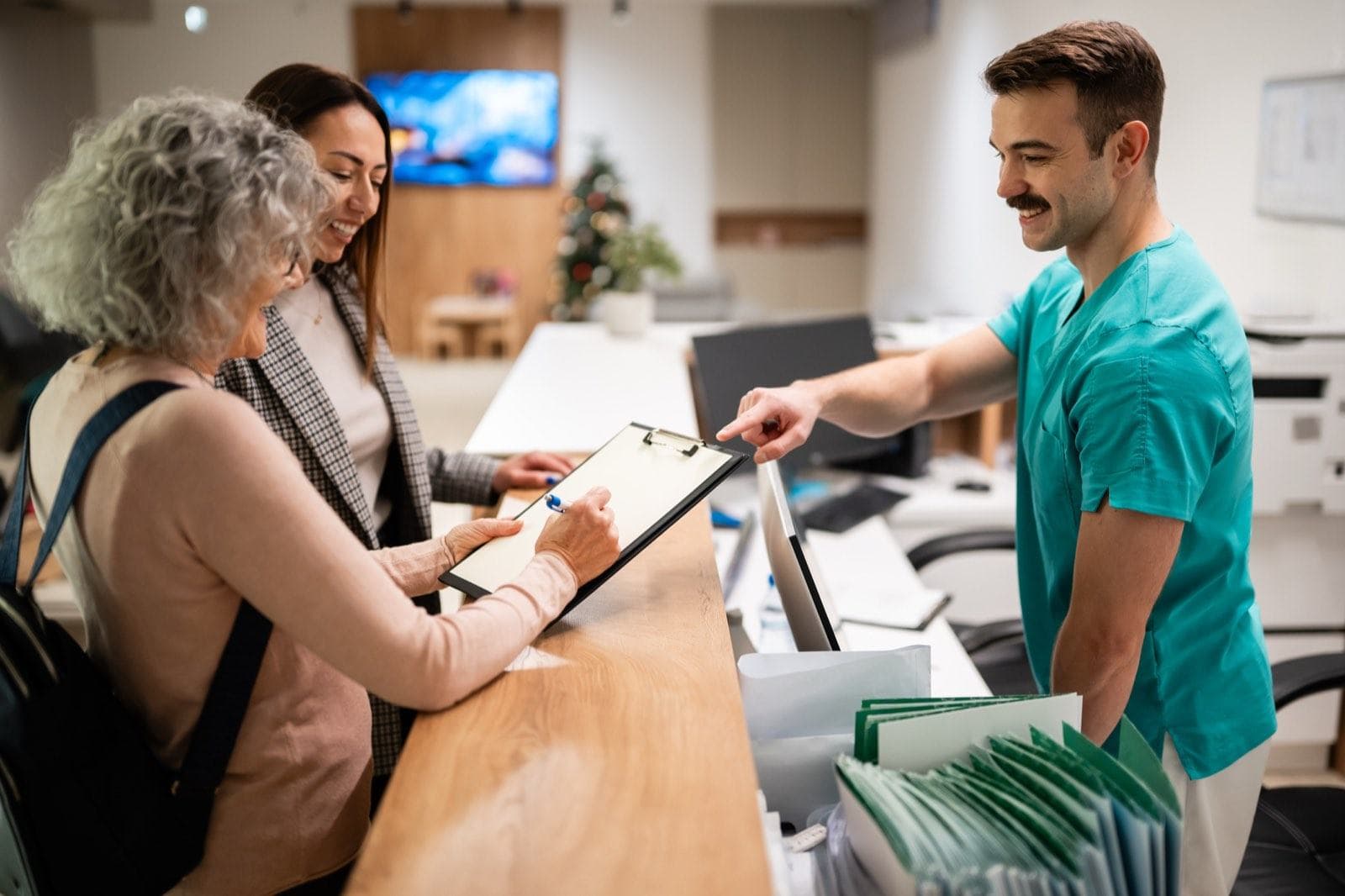 A family being welcomed at a clinic reception desk