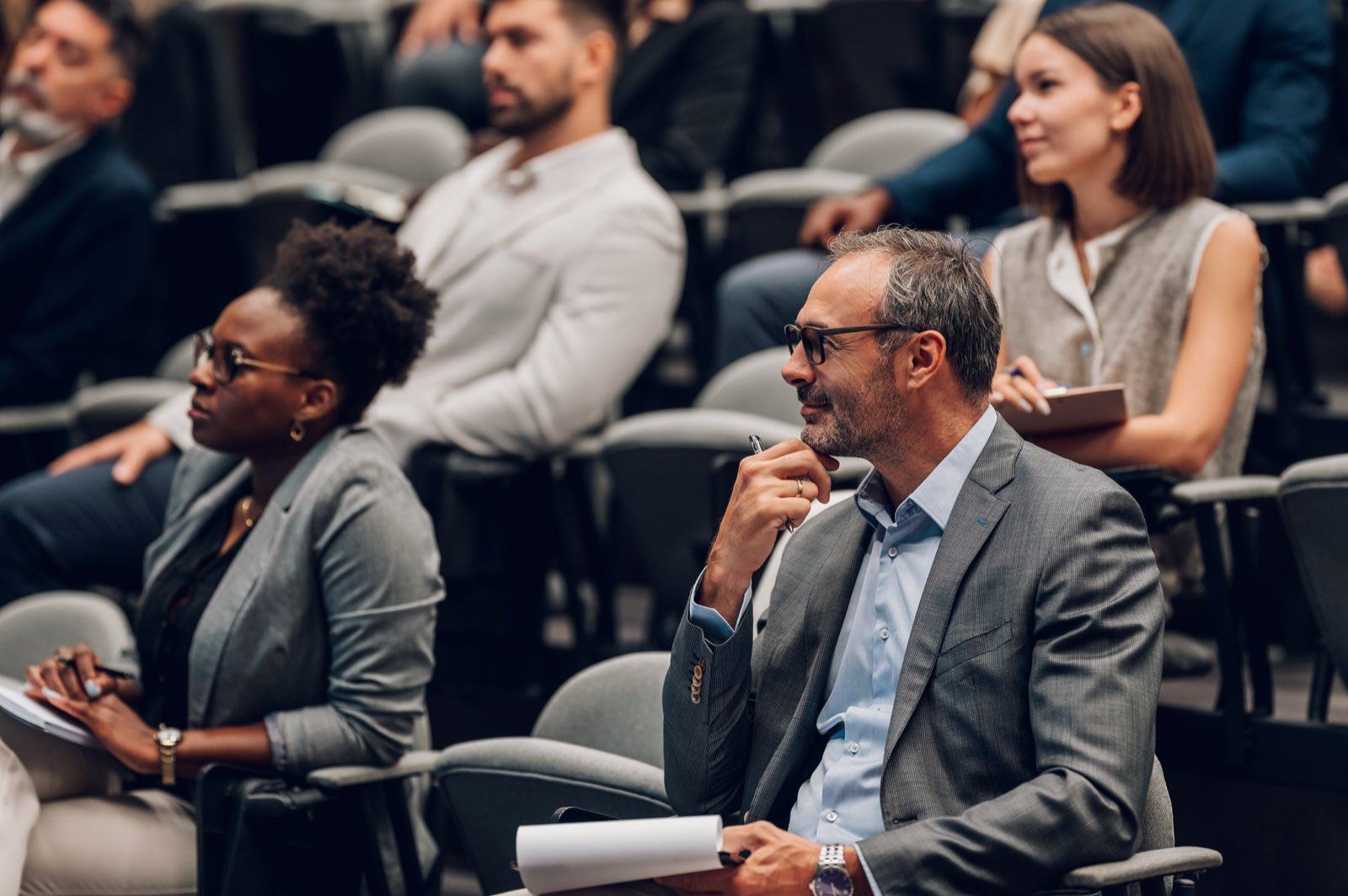 Professionals in a lecture hall listening to a conference talk